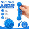 Una mano sostiene un juguete masticable dental de goma suave y azul, sin BPA, mostrando su textura y flexibilidad.