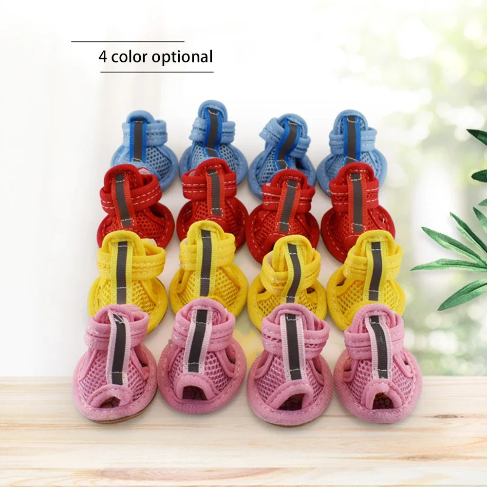 A set of four colorful summer dog and cat walking shoes displayed on a wooden surface.