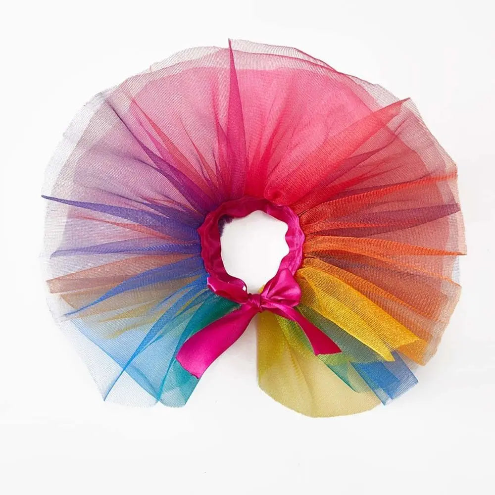 A colorful tulle tutu dress for a small dog, featuring shades of pink, purple, blue, and orange.