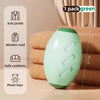 A light green reusable pet hair remover roller product shown next to clothing and toys.
