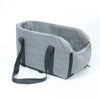 A gray portable pet car bed featuring a soft, fuzzy lining and a black safety strap.