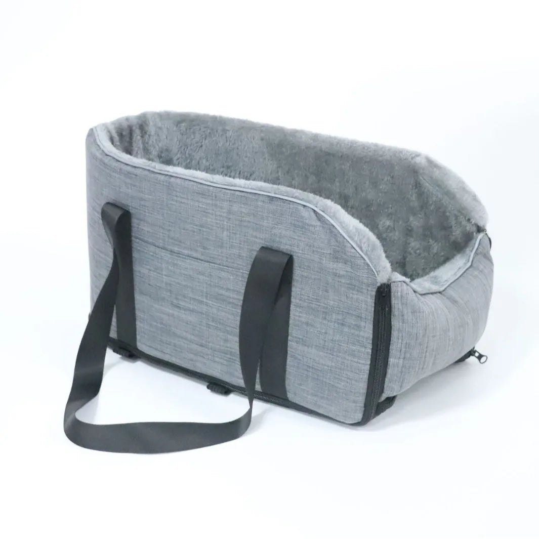 A gray portable pet car bed featuring a soft, fuzzy lining and a black safety strap.