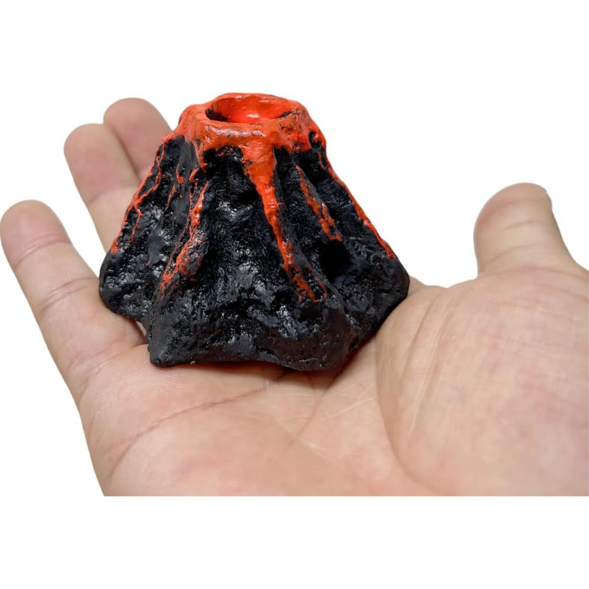 A dark volcanic rock sculpture with an orange lava flow effect, held in a person's hand.