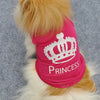 A fluffy puppy wearing a pink t-shirt with a white crown pattern.