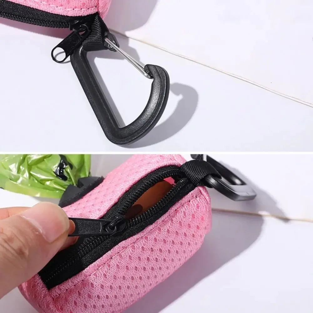 A pink mesh dog waste bag dispenser with a black strap and clip is shown on a white surface.
