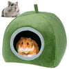 A green plush cave bed for small pets, featuring a circular entrance where a small orange hamster is visible.