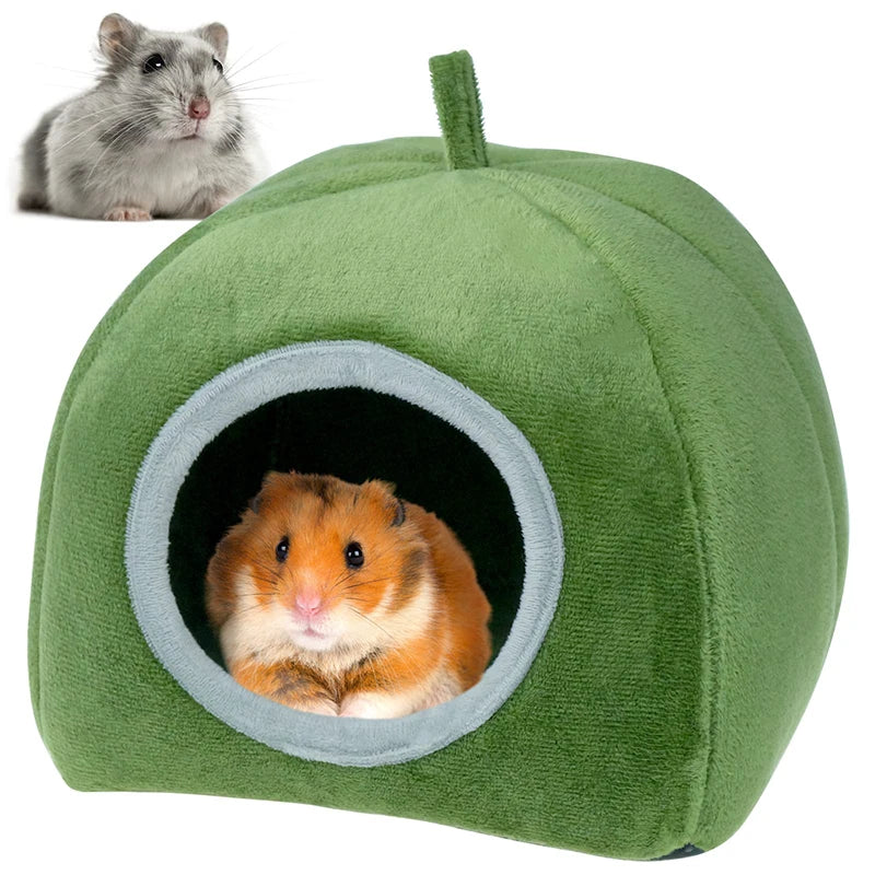 A green plush cave bed for small pets, featuring a circular entrance where a small orange hamster is visible.