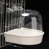 A clear plastic hanging bird bath for parakeets is shown inside a wire cage.