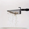 A black stretchable stainless steel scoop is shown tilting and spilling small debris, likely for cleaning animal habitats.