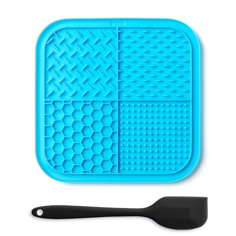 A bright blue silicone lick mat for pets with suction cups and a black silicone spoon.