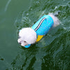 A white dog is wearing a blue and yellow summer life vest swim jacket in green water.