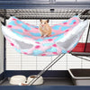 A small brown rabbit is resting in a pink and blue fleece hammock inside a wire pet enclosure.