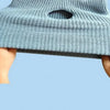 A light blue knitted dog head and warm mask accessory being held by a person's hand.