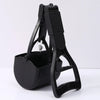 A black portable foldable dog poop scooper with a handle and container is shown on a white surface.