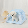 A light blue cozy pet tent bed for cats with a white fluffy puppy inside.