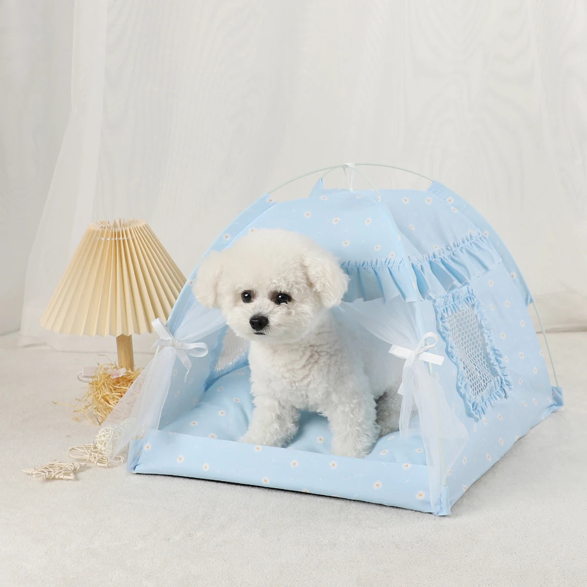 A light blue cozy pet tent bed for cats with a white fluffy puppy inside.