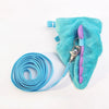 A teal fuzzy vest harness with purple trim and a silver clip is shown next to a coiled blue leash.