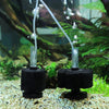 Un filtre sponge biologique noir avec de l'eau projetée par une pompe à air dans un aquarium.