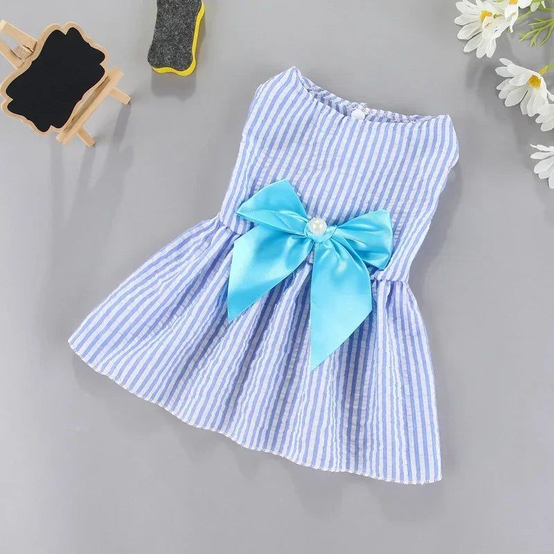 A light blue and white striped summer bow dress for a small pet, featuring a satin blue bow detail.