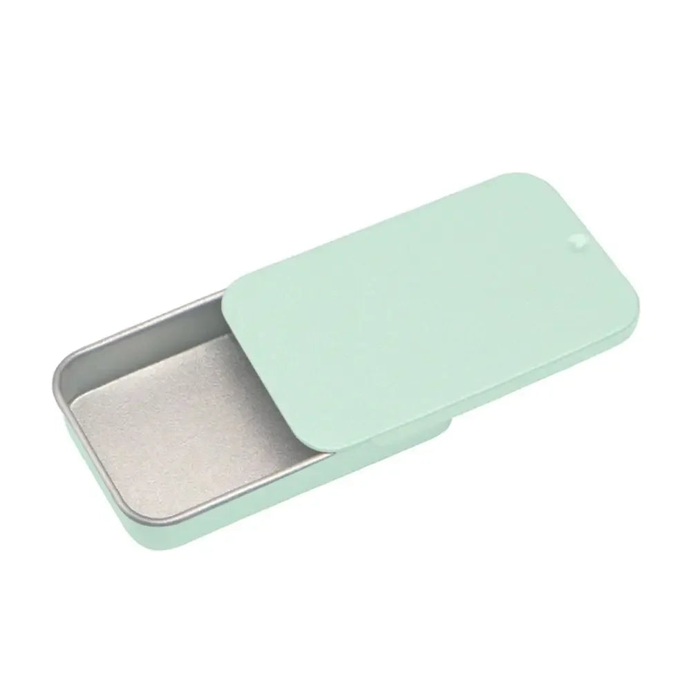 A light mint green compact sliding lid tin box for storing treats, pills, and small items.