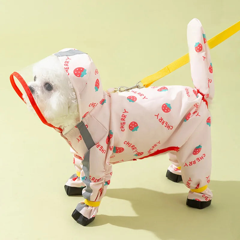 Un cachorro blanco de perro vistiendo un impermeable rosa con estampado de cerezas y tirantes amarillos.