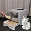 A white foldable cat litter box is shown with a cat sitting next to it on a dark surface.