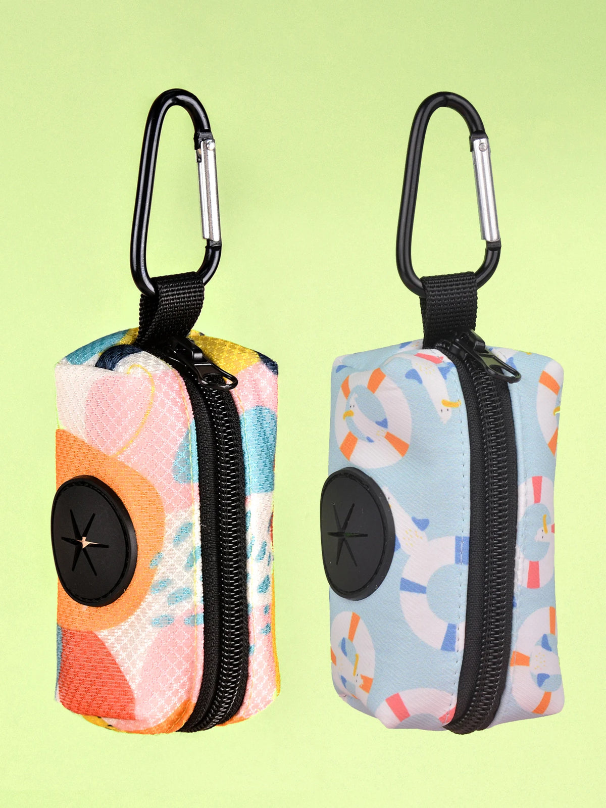 A pair of colorful, zippered poop bag holders with black handles and light blue, pink, and yellow patterned fabric.