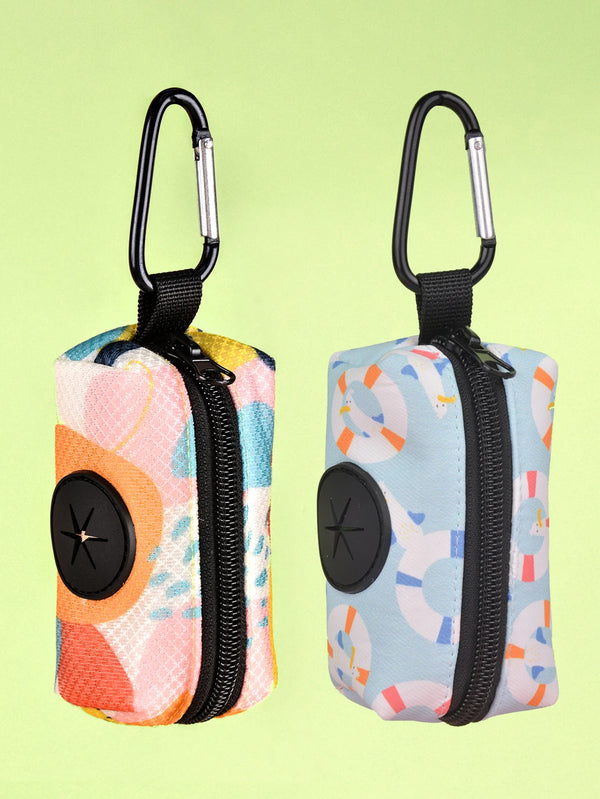 A pair of colorful, zippered poop bag holders with black handles and light blue, pink, and yellow patterned fabric.