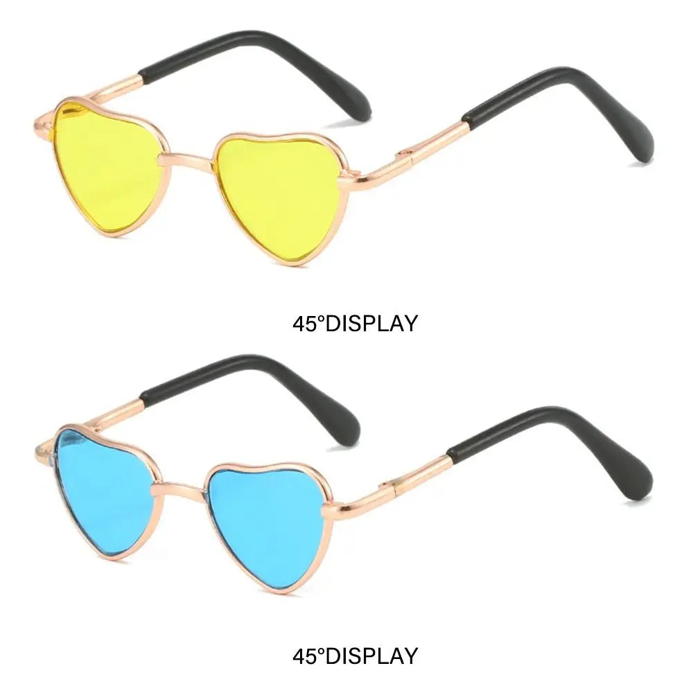 Pair of heart-shaped pet sunglasses, one yellow and one blue, with gold-toned frames.