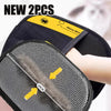 A pair of black pet grooming gloves with a gray textured pad and yellow accents shown in close-up.