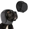 A black dog wearing a gray calming headgear and an accompanying black fabric piece.
