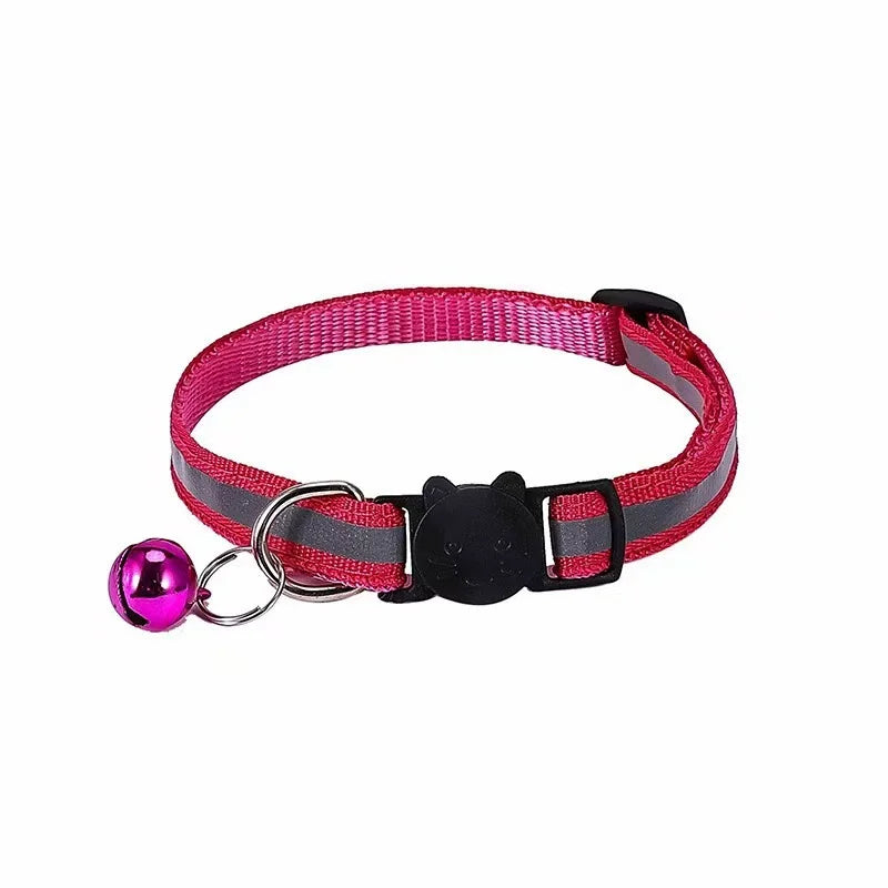 A pink reflective pet collar with a black head buckle and a purple ball attached.
