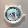Une porte d'animal ronde blanche avec une lentille transparente est fixée au mur.