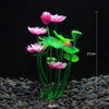 Un amas de plantes aquatiques artificielles rose et blanc avec des feuilles vertes poussant dans du gravier foncé.