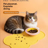 A tabby cat is resting on a yellow silicone pet placemat with food, demonstrating a pet tablecloth.
