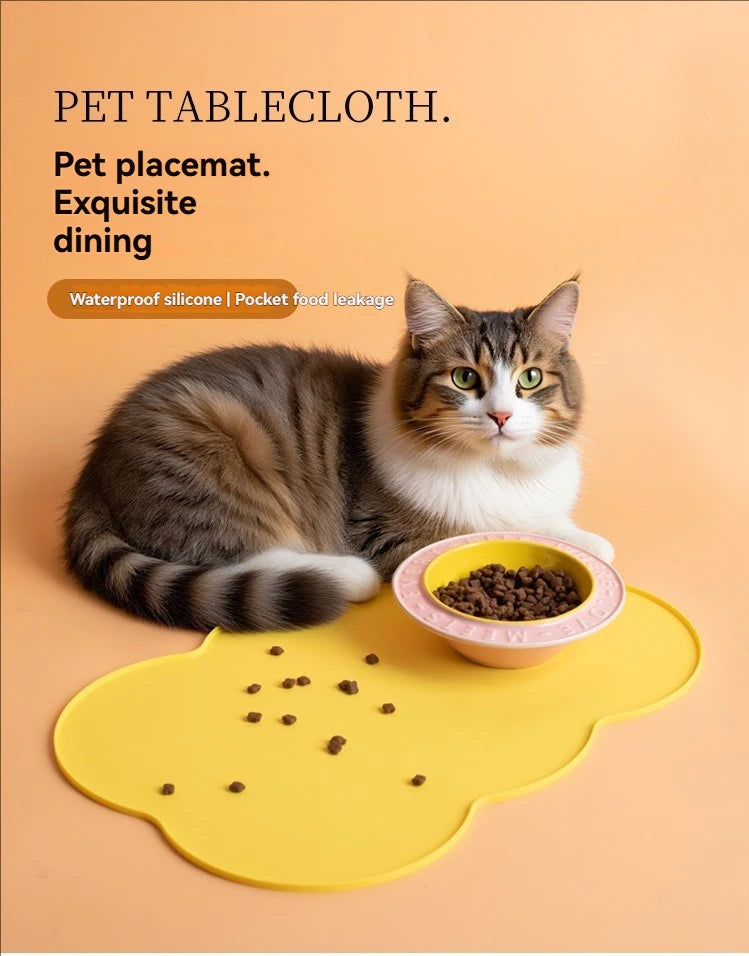 A tabby cat is resting on a yellow silicone pet placemat with food, demonstrating a pet tablecloth.
