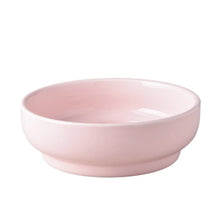 A pink ceramic cat and dog bowl with a stand.