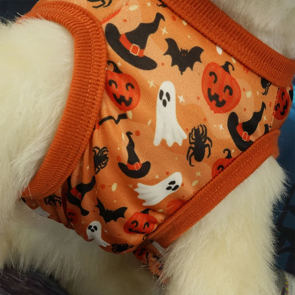 Un vestido naranja para perro con estampado de murciélagos y calabazas en un perro blanco peludo.