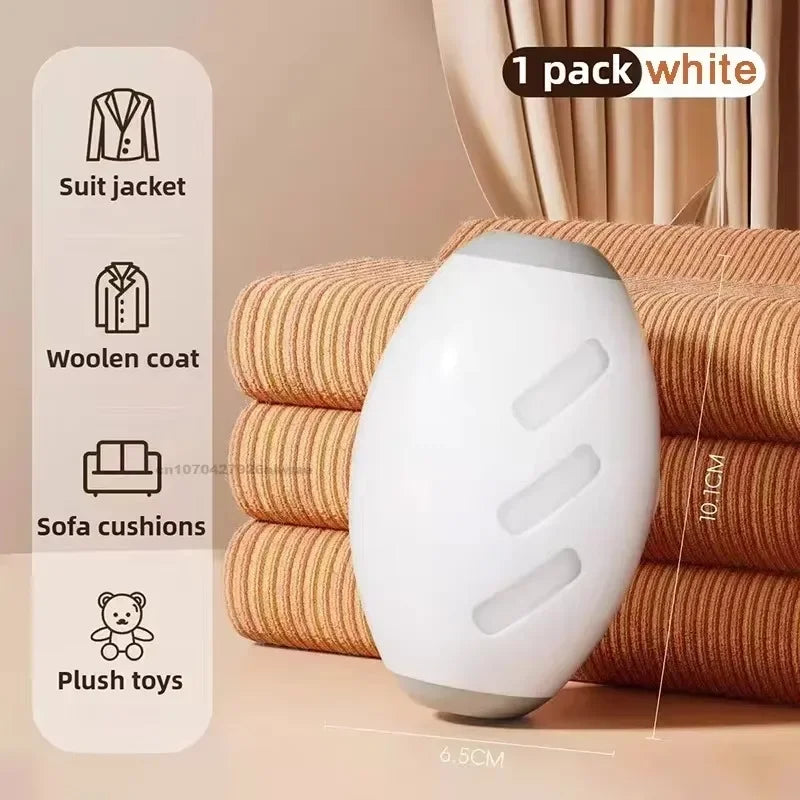A white reusable pet hair remover roller product shown next to folded fabric and clothing items.