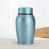 A light blue stainless steel pet memorial storage box with a heart and paw print engraved on the side.