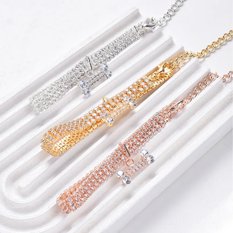 Gold and rose gold crystal rhinestone pet collar with a bone pendant displayed in a white box.