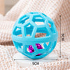 A bright blue natural rubber interactive dog chew ball with a bell resting on a white surface.