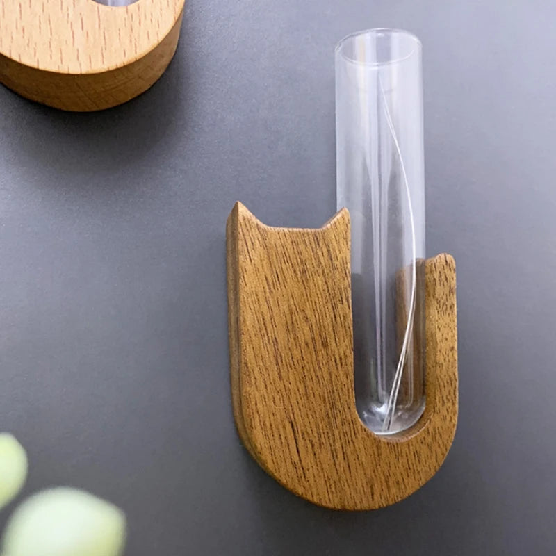 A wooden pet whisker collector vase with a clear glass tube for display.