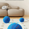 A bright blue, textured smart dog chew ball is shown resting on a light-colored rug.