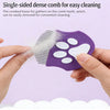 A purple single-sided dense comb with white teeth is being held by a hand, showing the loose fur gathering on the comb.