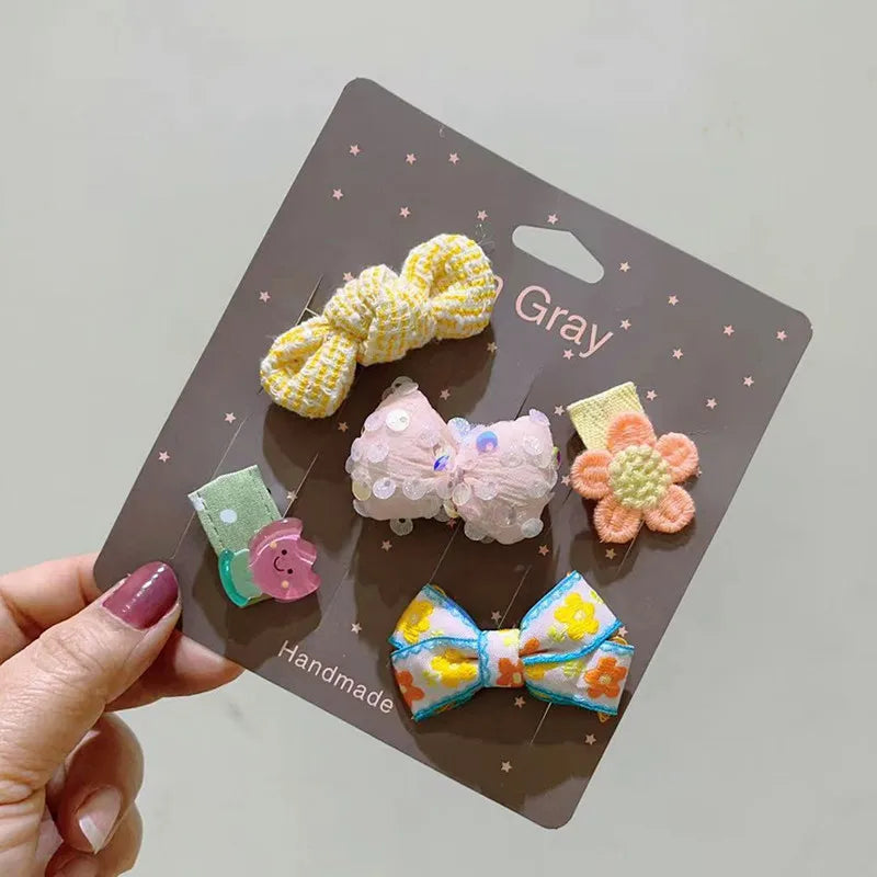 Tarjeta gris con un paquete de 5 lazos de moda hechos a mano rosa y amarillo para clips de pelo de perros y gatos.