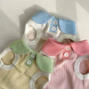 A knitted dog t-shirt with a layered collar featuring light blue, white, and pink accents.