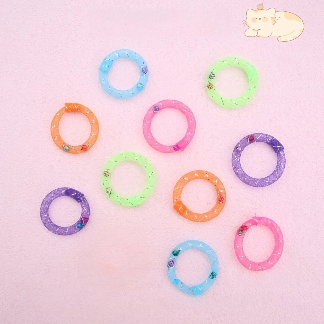 A collection of colorful, soft mesh donut chew toys in various colors like blue, green, orange, and purple are scattered on a