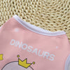 Pink sleeveless vest for pets featuring a dinosaur design on a woven natural background.