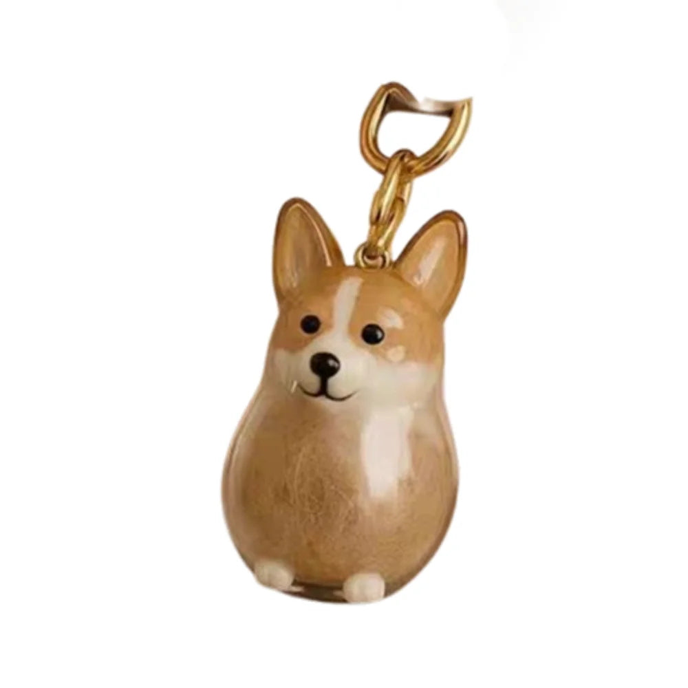 Una pequeña figura de perro de cartón marrón claro con un anillo de llavero dorado adjunto.